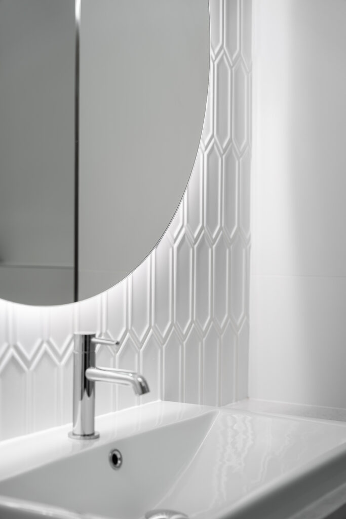 Jasny akcent dekoracyjny na ścianie przy umywalce